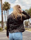 Back of woman wearing lightweight belted leather motorcycle jacket