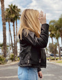 Side of woman wearing lightweight belted leather motorcycle jacket