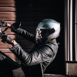 Motorcycle rider doing a wheelie while wearing Glide model modular motorcycle helmet in Silver Metallic